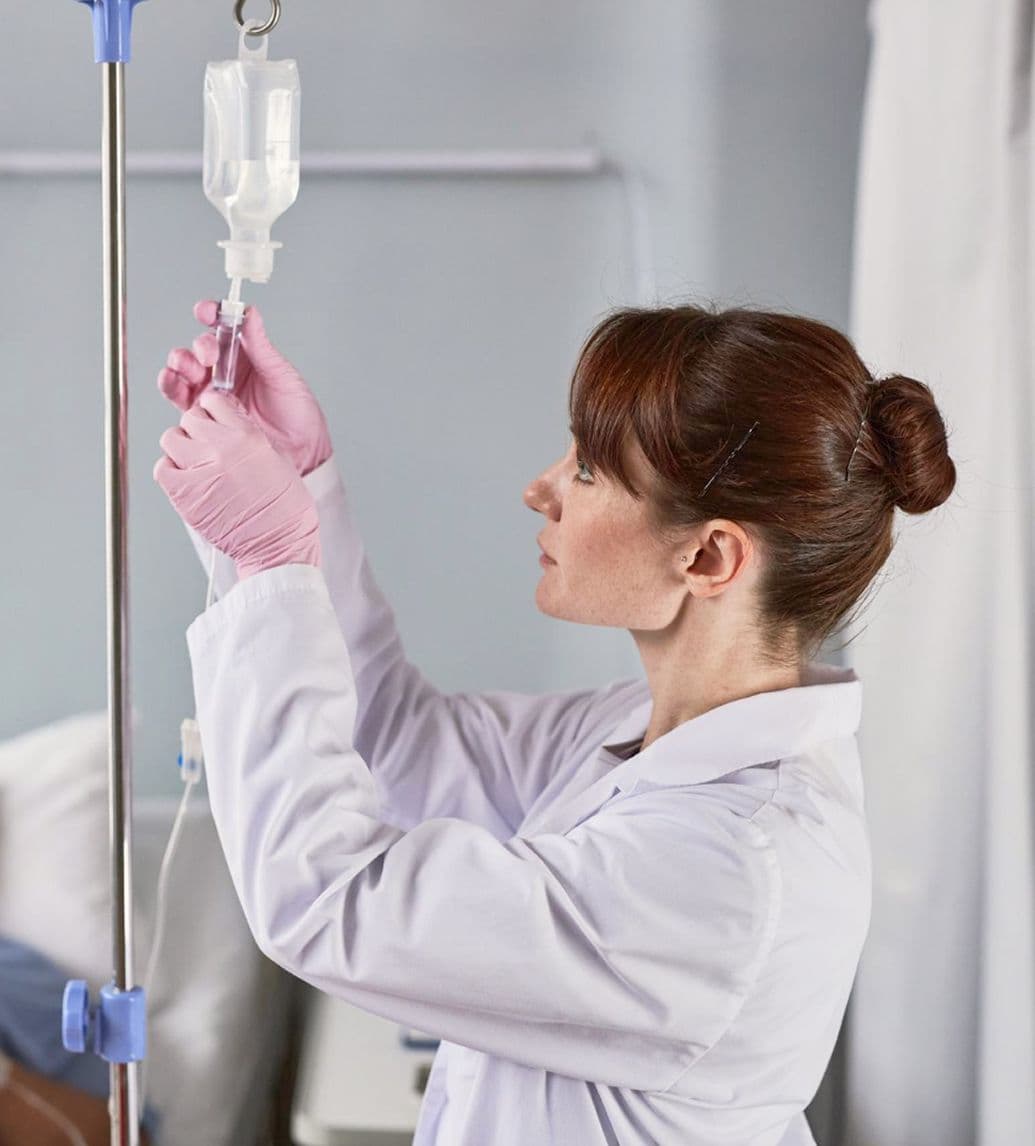Девушка-врач ставит капельницу пациенту